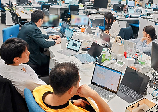 デスクで仕事をする報道部員