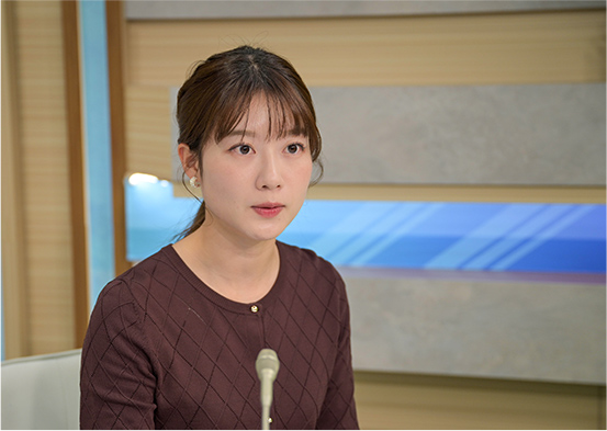 報道スタジオでマイクに向かっているキャスター