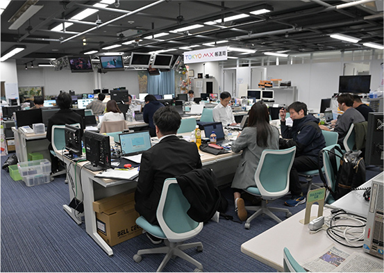 デスクがたくさん並び報道部の社員が仕事をしているフロア