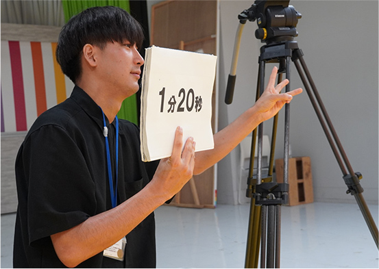 カンペを出すスタッフ